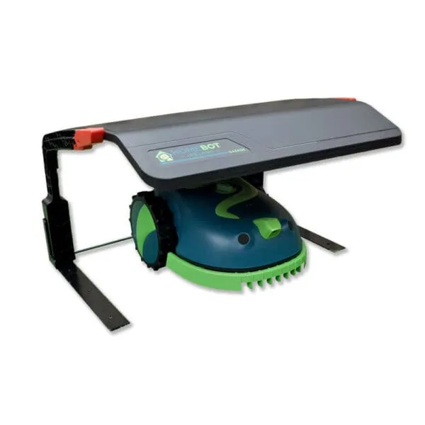 A light green and dark green robotic lawn mower Buddy, sits under a sleek black and grey Rain Shelter HB01. The device has large wheels and a compact, rounded body. The entire setup is supported by a sturdy black frame.